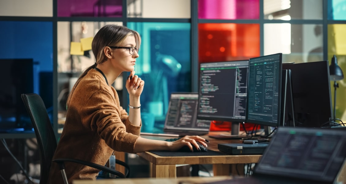 Software engineer writing code for an MVP project in a colorful, creative workspace