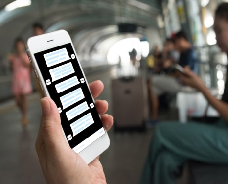 Person holding a smartphone with a chatbot interface displayed on the screen