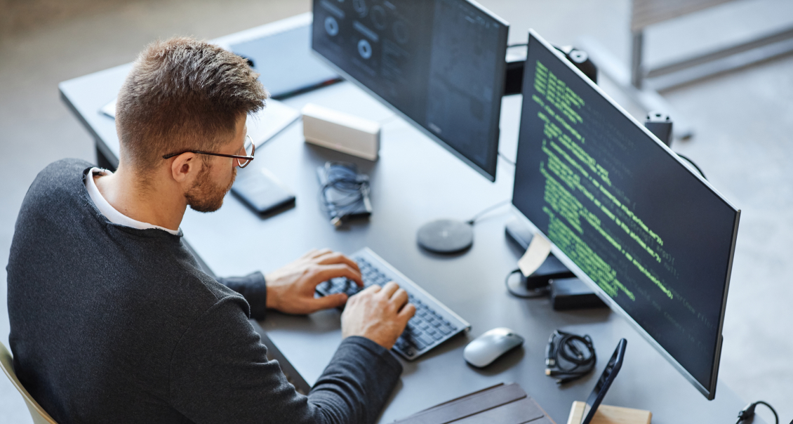 Developer writing enterprise-level code on multiple monitors for software development