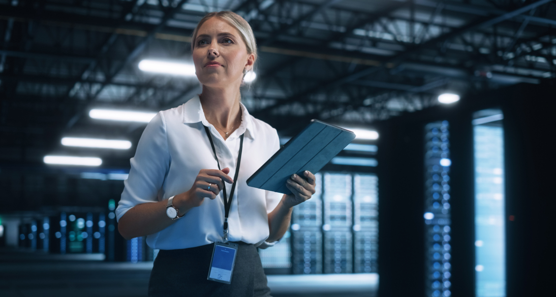 Data analyst managing enterprise IT operations with a tablet in a secure data center