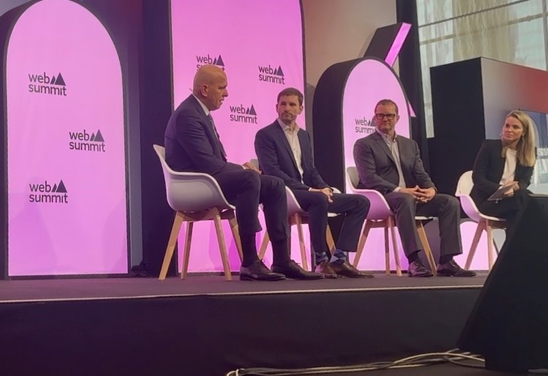 Ihab Foudeh, Alexander Mann, and Steven Malony discussing AI tech strategies on a WebSummit stage, hosted by Julia Sieger
