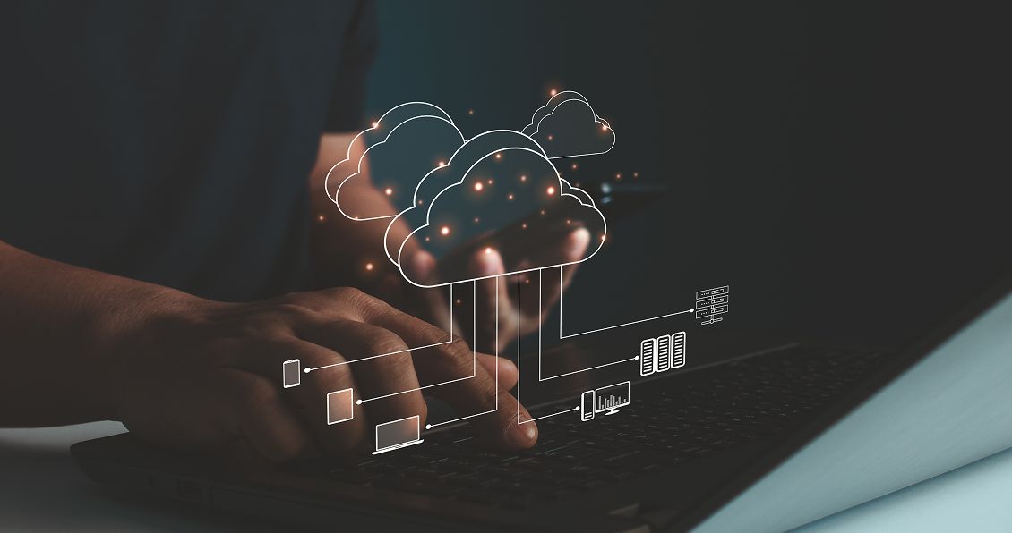 Hands typing on a keyboard with a holographic cloud computing network overlay