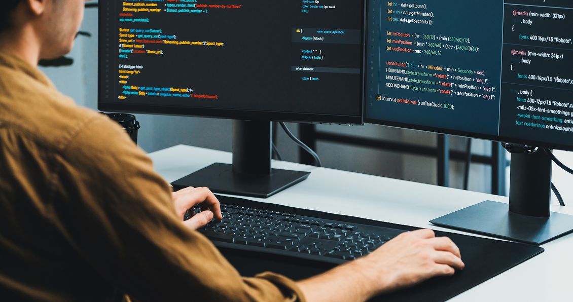 Java developer coding on dual monitors in a modern office