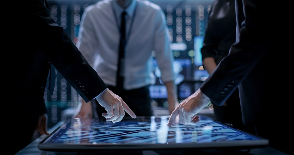 Team discussing software architecture over an illuminated digital interface