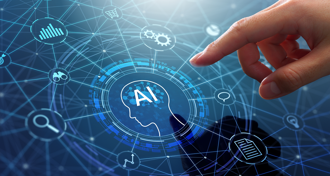 A human hand points toward a digital interface featuring a glowing profile of a human head labeled AI. The background displays interconnected icons, gears, graphs, and document symbols, suggesting artificial intelligence and technology integration.