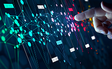 A hand points toward a digital screen displaying a colorful network of interconnected nodes and lines, representing data or neural networks. Various glowing dots and connecting lines create a complex, abstract visualization of technology or analytics.