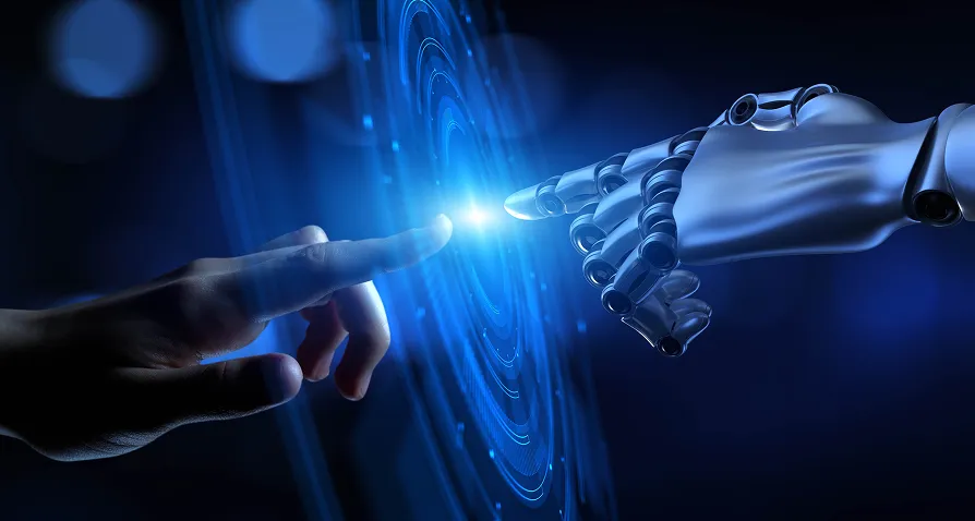 A human hand and a robotic hand reach towards each other, with their index fingers nearly touching a glowing blue digital interface, symbolizing connection and interaction between humans and advanced technology. The background is dark and futuristic.