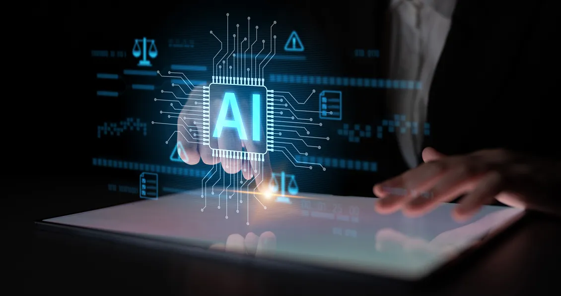 A person’s hand hovers over a digital tablet, with a glowing “AI” microchip graphic above it. Blue circuit lines and digital icons surround the AI chip, symbolizing artificial intelligence and advanced technology. The background is dark and futuristic.