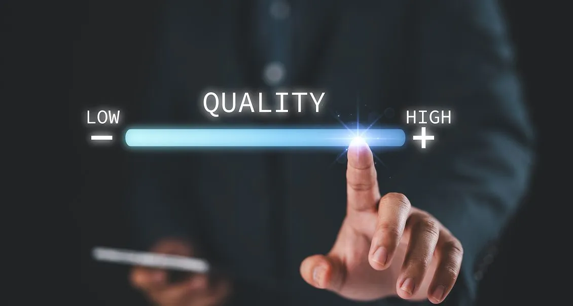 A person in a suit touches a glowing spot on a horizontal quality bar, moving the indicator from Low on the left to High on the right. The word QUALITY is displayed above the bar, and the background is dark and blurred.