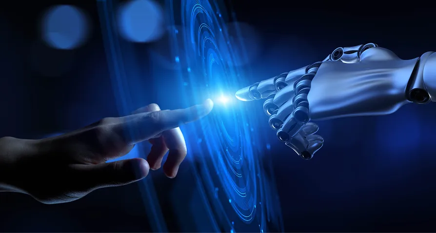 A human hand and a robotic hand reach toward each other, nearly touching fingertips, with a glowing blue digital interface between them, symbolizing the connection and interaction between humans and artificial intelligence or advanced technology.
